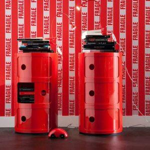 Auch Designklassiker wie der Kartell Componibili gehören zu den Interior Trends 2026. Hier im Doppelpack in knalligem Rot vor einer rot-weißen Wand.