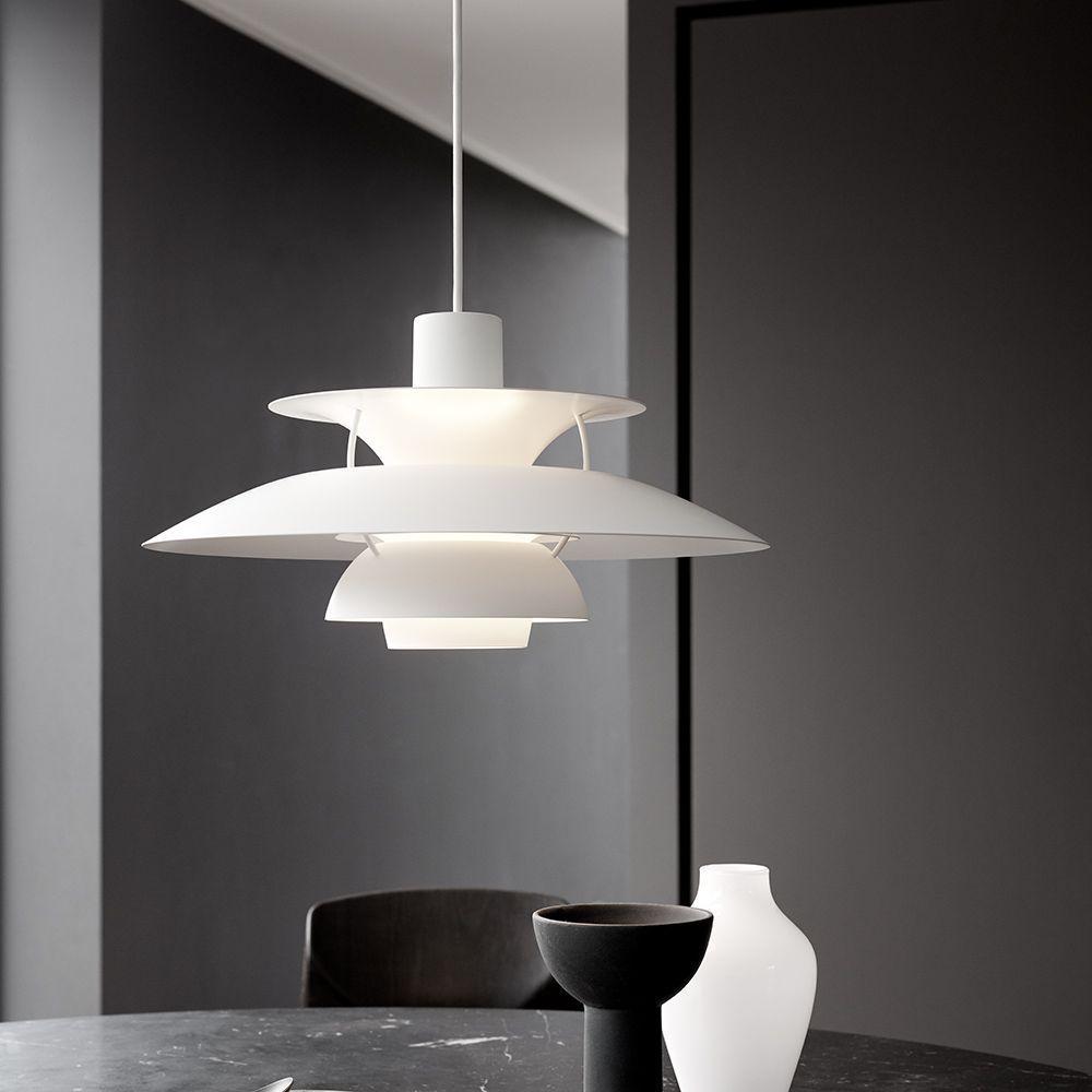 Wundervoll ästhetisch: Weiße Louis Poulsen PH 5 Pendelleuchte über einem modernen schwarzen Marmor-Esstisch.
